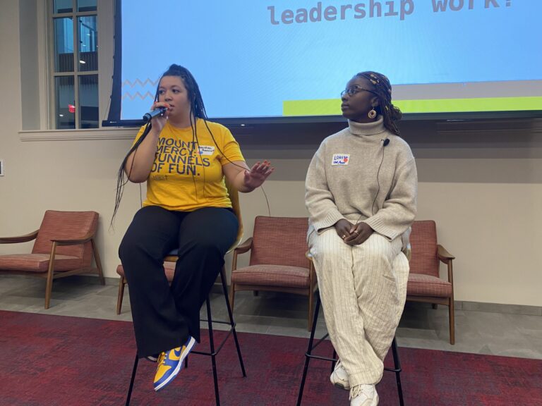 A photo of Ms. Ba and Houston Hamlett sitting and speaking at a conference room.